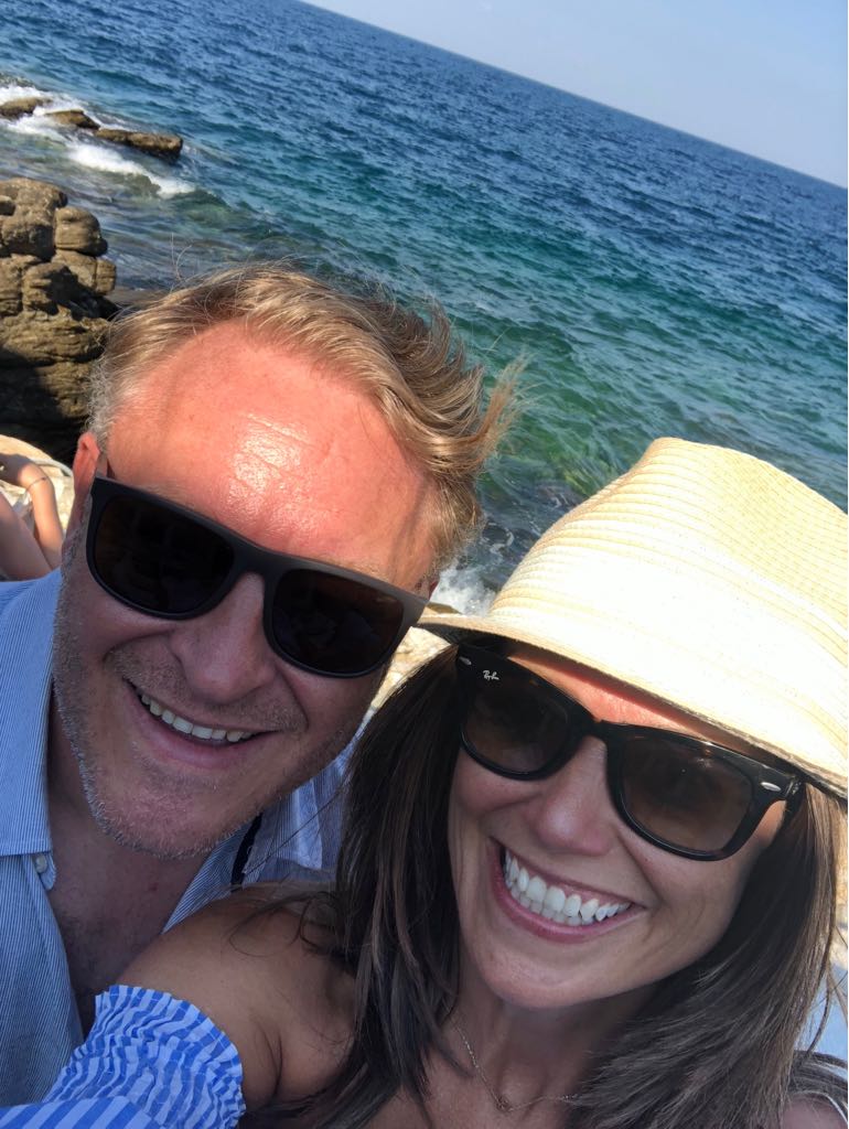 The team — a husband and wife smiling by the sea